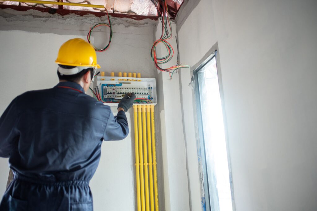 an electrician is wiring the house electrician working on electrical wiring in a new construction