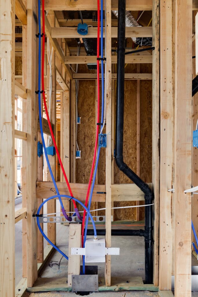 electrical wiring is neatly affixed in the interior wall of a new house construction site.