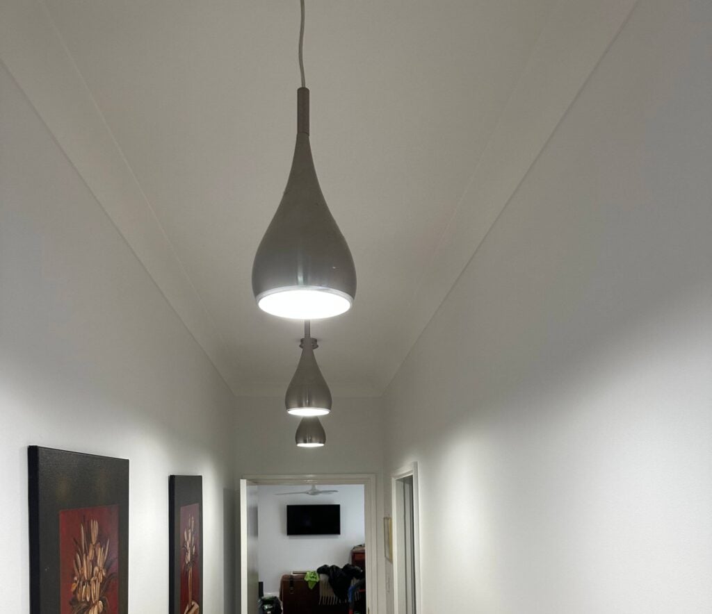 Three contemporary, teardrop-shaped pendant lights suspended at varying heights from the ceiling.
