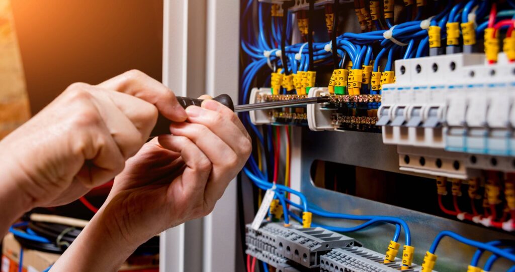 the man is repairing the switchboard voltage with automatic switches