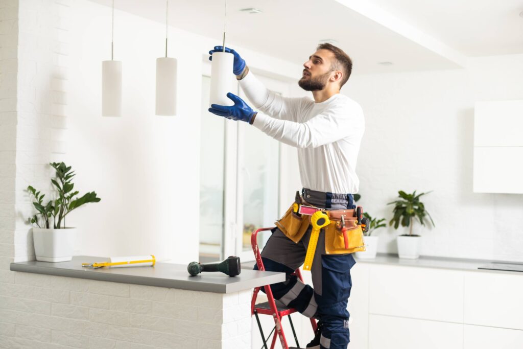 electrician installing led light bulbs in ceiling lamp
