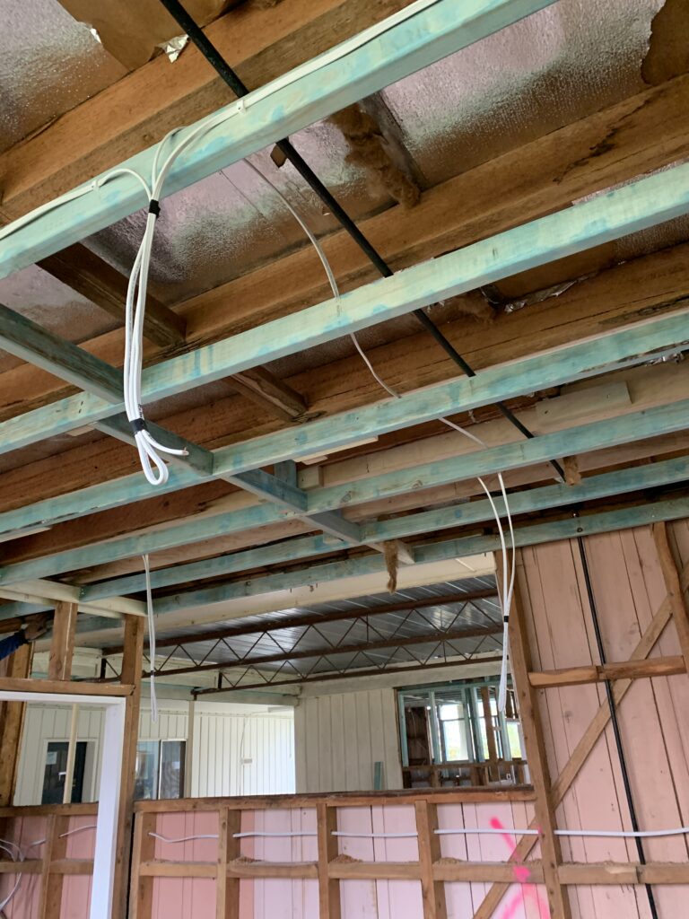 A room under renovation or construction, showing the exposed ceiling and wall structure.