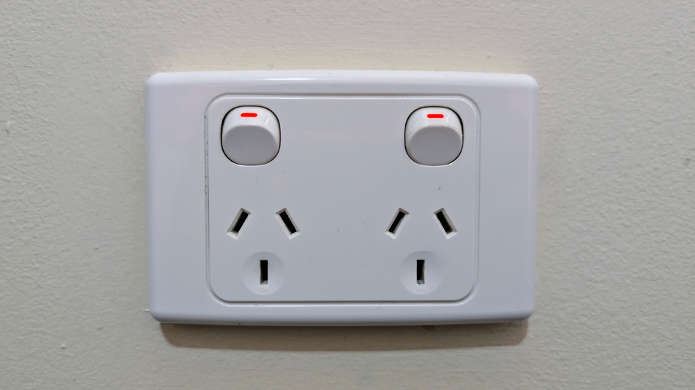 A white double power outlet (two-gang socket) mounted on a light-coloured wall, likely an Australian or Type I standard.
