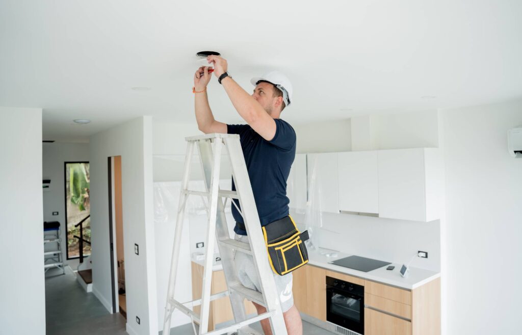 technician is installing an led spotlight in the ceiling.