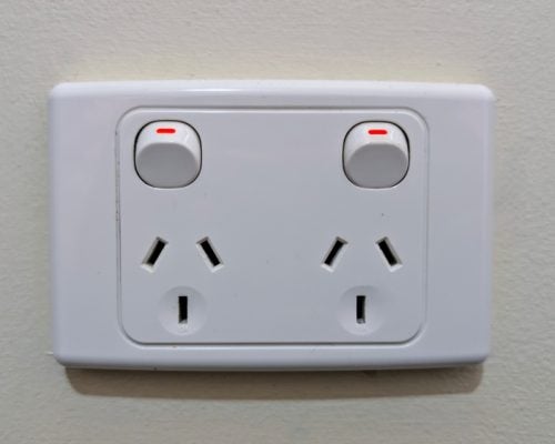 A white double power outlet mounted on a light-coloured wall, likely an Australian or Type I standard.
